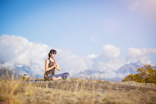 Yoga nel parco. Giovane ragazza pratica yoga all'aperto.