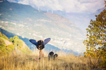 Giovane coppia pratica acroyoga e yoga all'aperto in montagna al parco
