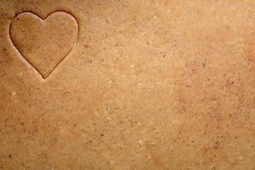 Brown background from ginger dough with heart in the left corner