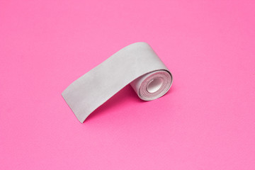 Silver tape to reflect light on a pink background, close-up, visibility on the road, safety, bandage