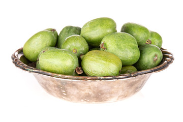 Lot of whole fresh green mini baby kiwi fruit in old iron bowl isolated on white background