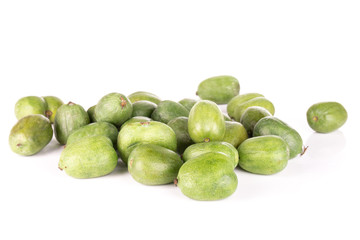 Lot of whole fuzzless fresh green mini baby kiwi fruit isolated on white background