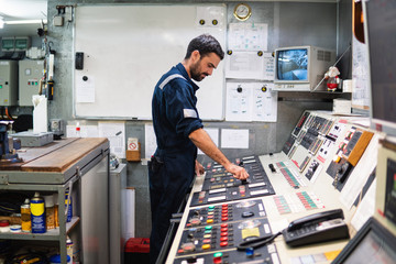 Marine engineer officer in engine control room ECR. Seamen's work. He starts or stops main engine...