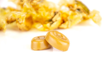 Group of two whole caramel cream candy butterscotch variety with yellow shiny covered bonbons isolated on white background