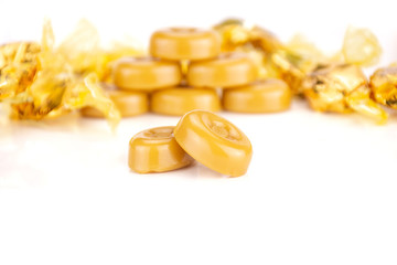 Lot of whole caramel cream candy butterscotch variety front focus isolated on white background