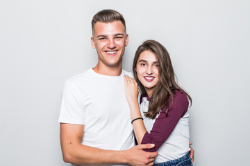 Portrait of happy couple looking at camera against gray background