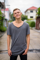 Young man wearing gray shirt in the streets outdoors