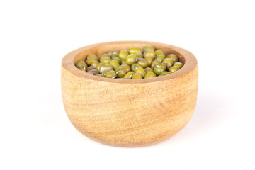 Lot of whole dry green mung beans with wooden bowl isolated on white background