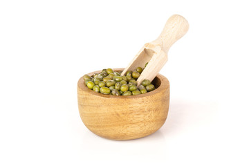 Lot of whole dry green mung beans light scoop with wooden bowl isolated on white background