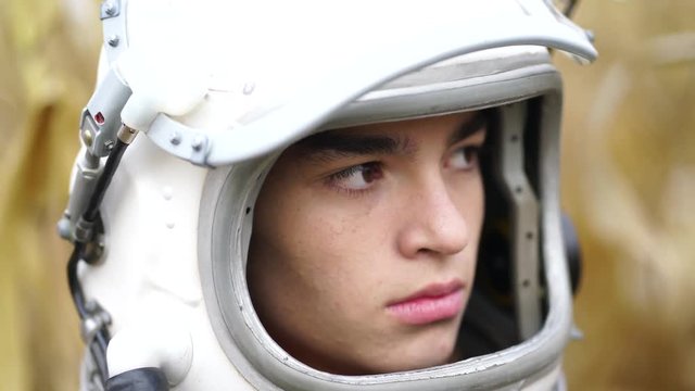 Boy wearing old space helmet lost in the field