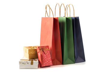 Colourful paper shopping bags with gift boxes on white background