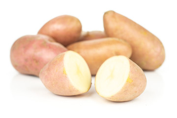 Group of five whole two halves of fresh red potato francelina variety front focus isolated on white background