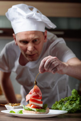 Chef prepares a snack with mozzarella and smoked meat .