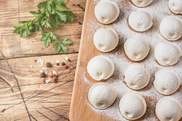 Raw dumplings on a wooden chopping Board in the kitchen Copy space