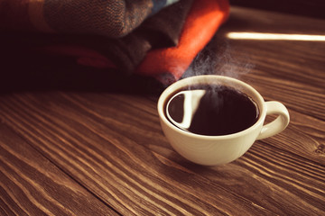 a hot Cup of coffee on a background of wool, a vintage image selective focus