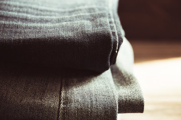 stack of jeans on wooden background, toning vintage image