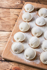 Raw dumplings on a wooden chopping Board in the kitchen