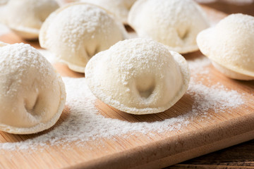 Fototapeta na wymiar Raw dumplings on a wooden chopping Board in the kitchen
