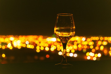 Wine glass against the background of the night city, bokeh