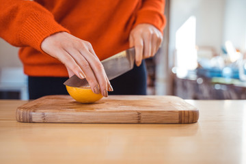 Woman cutting, peeling oranges preparation concept in home kitchen  
