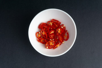 Red chili slices on dark background with selective focus and crop fragment