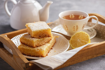 Homemade baked lemon bars and cup of tea.
