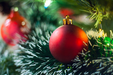 Red Christmas ball on the branches fir. Colorful balls. Christmas Decoration During Christmas and Happy New Year. Background blur. Closeup of red Christmas balls.
