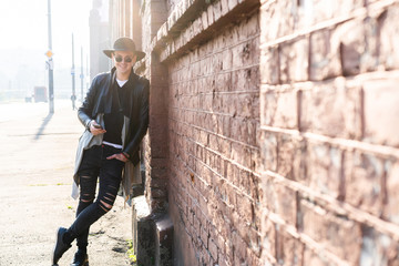 Fototapeta premium Young man posing with a trendy outfit against a urban background.