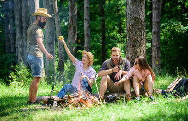Camping and hiking. Company friends relaxing and having snack picnic nature background. Company hikers relaxing at picnic forest background. Relax in nature environment. Halt for snack during hiking