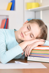 Portrait of a cute schoolgirl sleeping at table