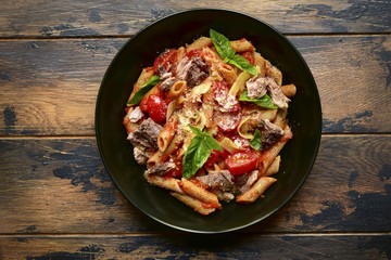 Wholegrain penne pasta with tomato and tuna in red sauce.Top view.