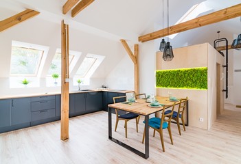 Wooden set table and modern kitchen in the attic - obrazy, fototapety, plakaty
