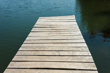 Obraz premium Fragment of an old wooden pier on the background of water