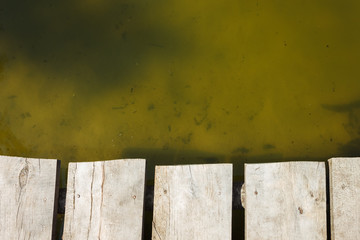 Fragment of an old wooden pier on the background of water. Copy space. Background 