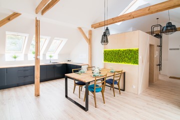 Open bright kitchen with black kitchen cabinets and table