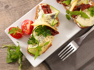 bread slice with zucchini, cheese cream and tomato