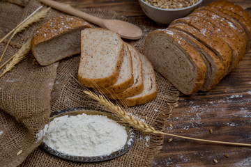 White wheat sliced tasty and delicious bread on wooden background