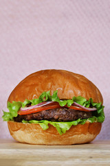 burger on pink background. burger on wooden tray and pink background