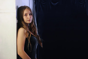 portrait of a young attractive girl on dark background and light wall