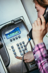 Junges M&auml;dchen telefoniert in alter Telefonzelle, M&uuml;nztelefon