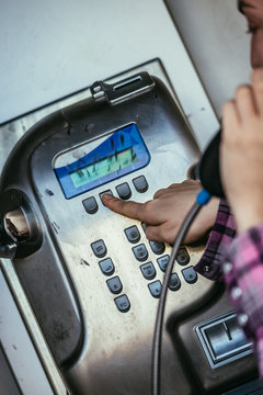 Junges Mädchen telefoniert in alter Telefonzelle, Münztelefon
