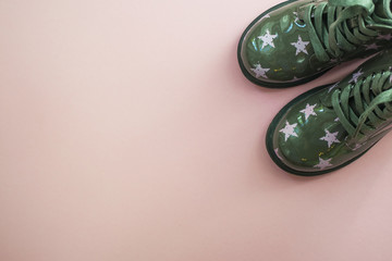 Cute child's green color shoes on pink background.