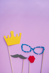 Photo booth props glasses, crown and lips on pink background.