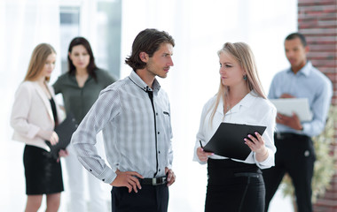 businessman and business woman standing in a modern office.