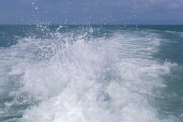 Fototapeta na wymiar Blue ocean sea water wave with fast yacht boat wake foam of prop wash . Close up