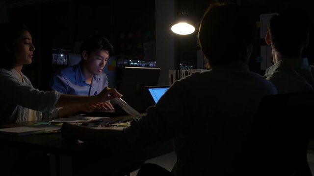 Business people team meeting together and hard working to late night at office. Employee work overtime. Concept of relaxation is not enough and busy meeting room.