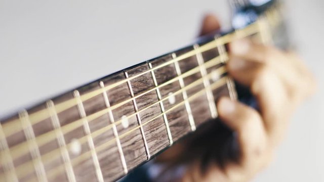 Guitar being played close up on the white background