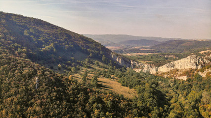 Fototapeta na wymiar Aerial view of mountains in national park Cheile Nerei Beusnita in Romania. Part of Carpathian mountains with beautiful autumn colors.