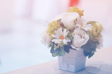 Close up vase of white rose with flowers and green leafs on pastel tone.