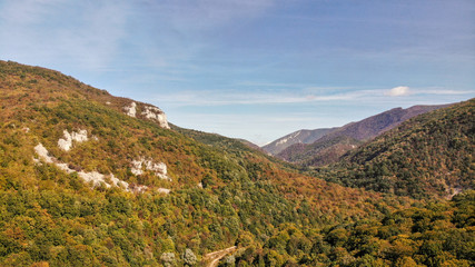 Fototapeta na wymiar Aerial view of mountains in national park Cheile Nerei Beusnita in Romania. Part of Carpathian mountains with beautiful autumn colors.